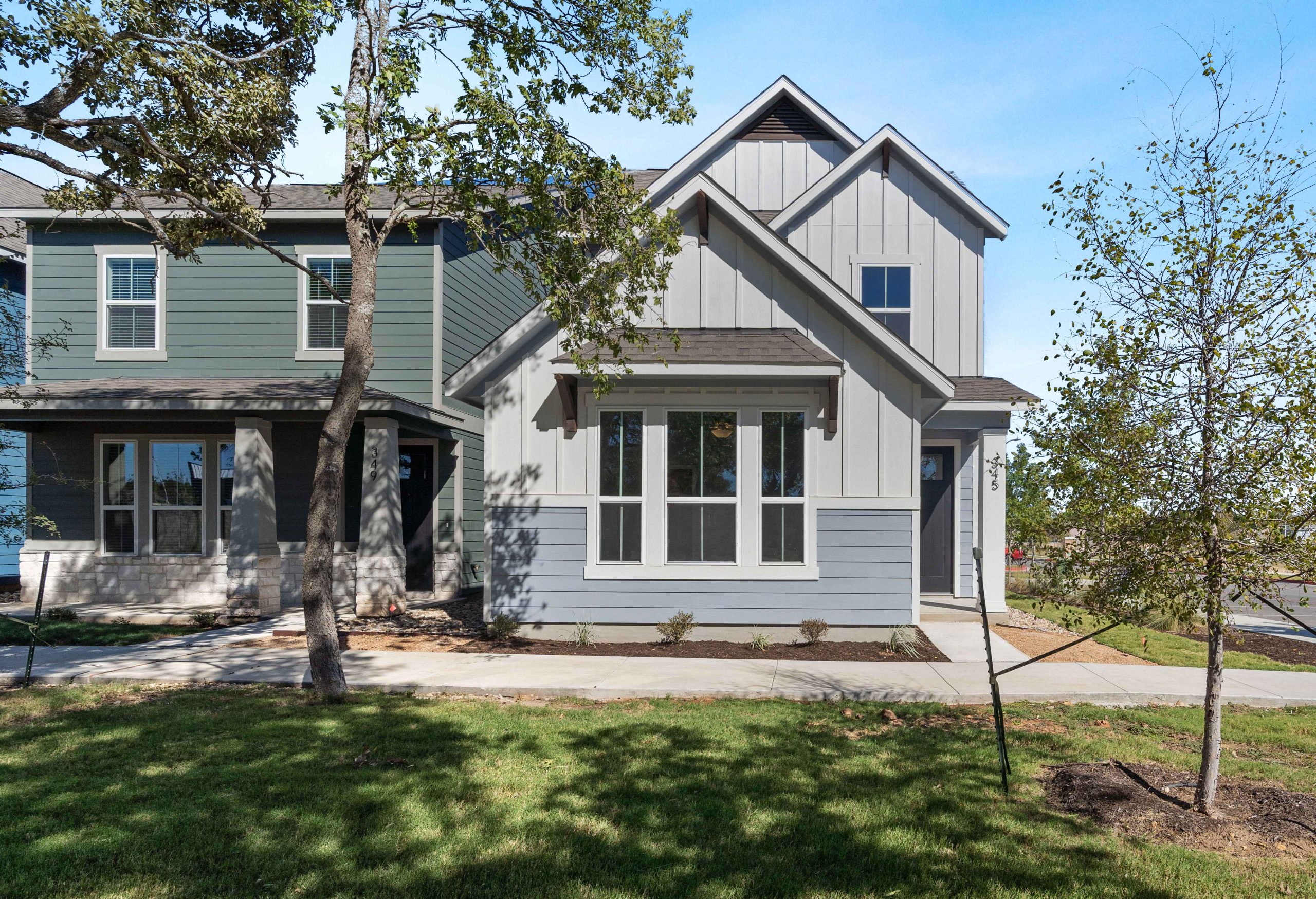 Retreat at Hero Way home with shaded front yard and modern tiered roof design